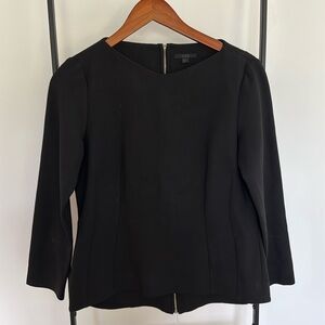 Black top by COS. Zipper in the back. Good condition